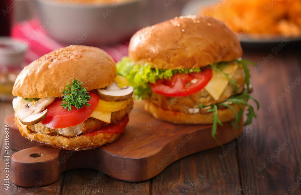 Two turkey burgers on wooden board, close up Two turkey burgers on wooden board, close up