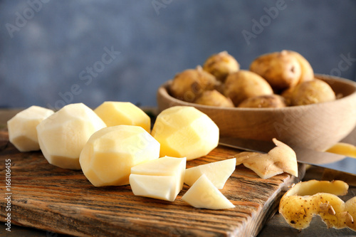 Composition with peeled raw organic potatoes on table