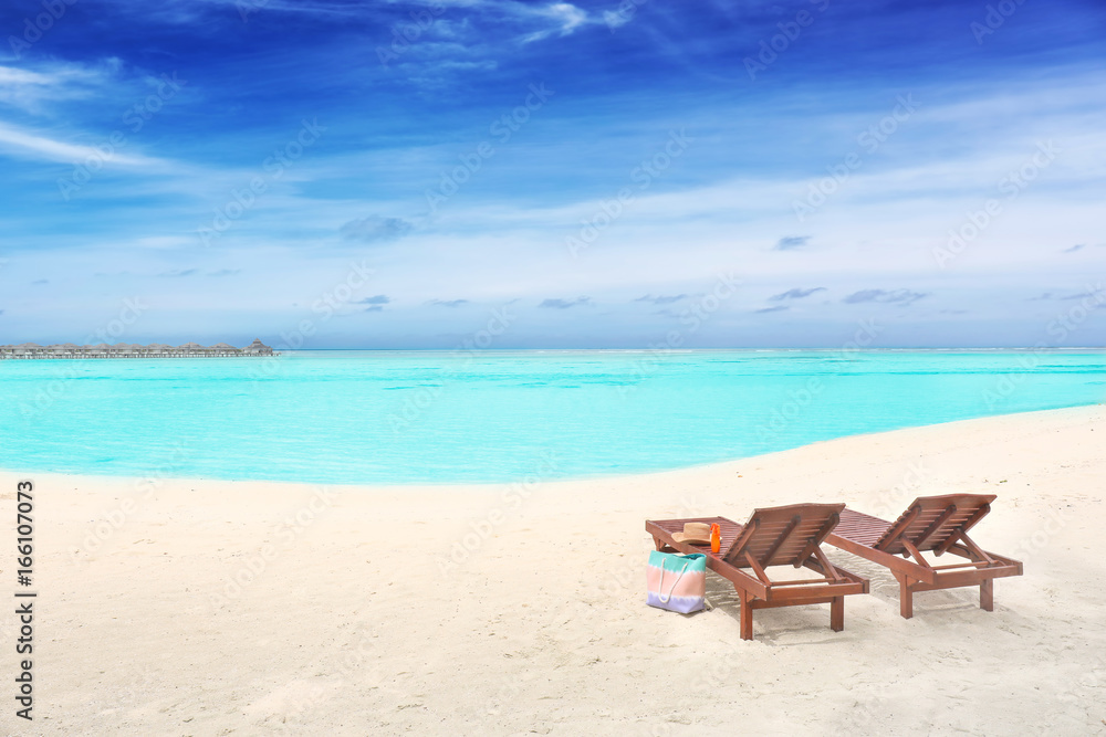 Wooden sun loungers with beach accessories at sea resort