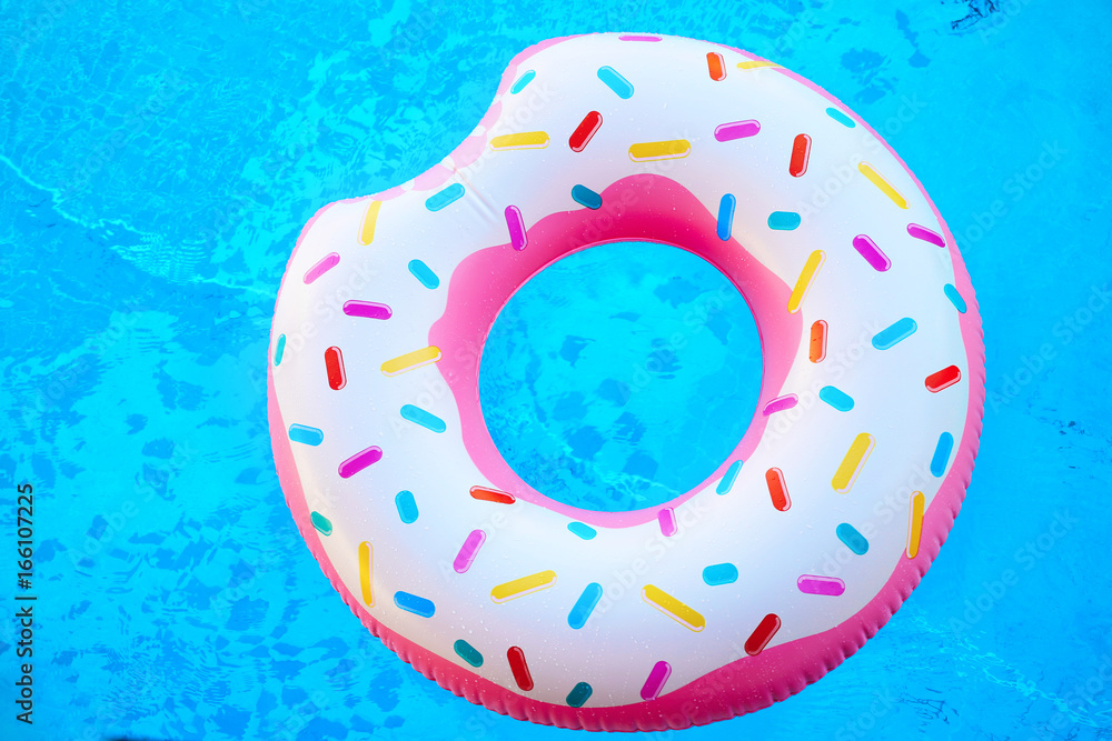 Inflatable colorful donut in blue swimming pool Inflatable colorful donut in blue swimming pool