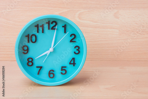 Green clock on wood background , Clock to tell time Create a plan to manage the hustle of life or work.