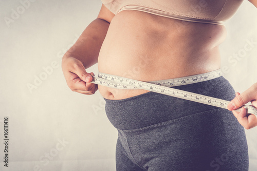 fat woman measuring her stomach,vintage fillter photo