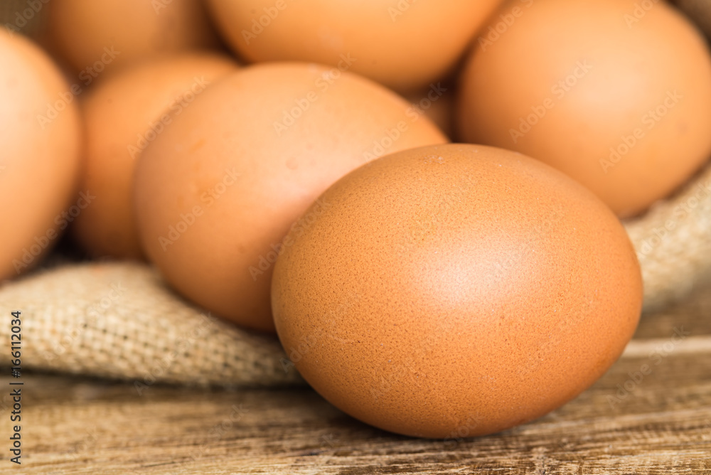 chicken eggs in brown gunny sack on wooden table ,close up chicken eggs in brown gunny sack on wooden table ,close up