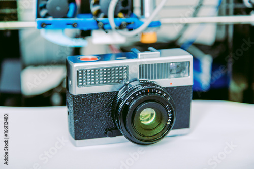 Automatic three dimensional 3d printer performs Vintage camera.Old retro , vintage camera on vintage abstract background