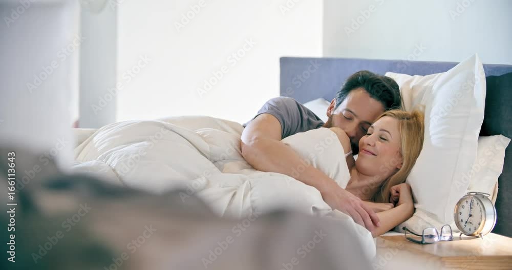 Blonde woman and man smiling, hugging and sleeping. Couple in love morning wake up at home in bedroom. Caucasian girlfriend and boyfriend people liying on bed. Lovely strokes. 4k video