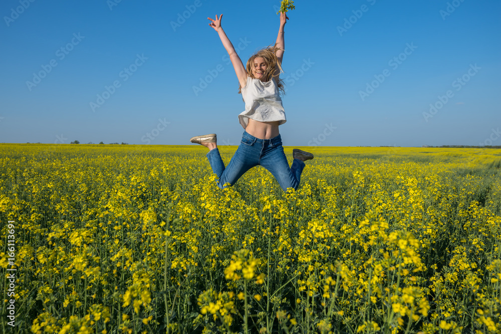 Smiling young woman jumping in a field Smiling young woman jumping in a field