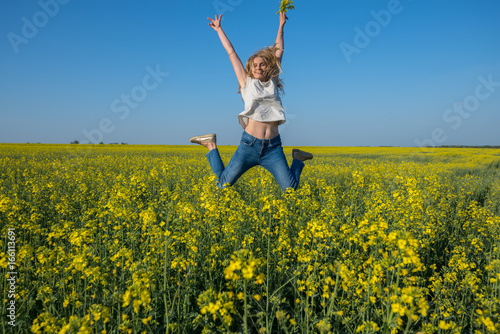 Smiling young woman jumping in a field