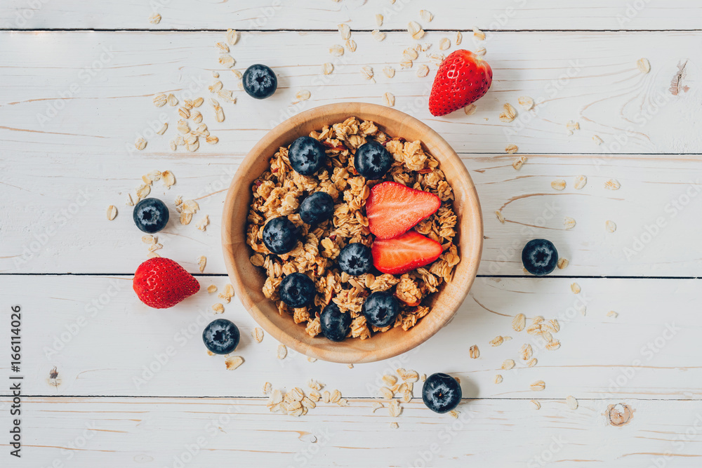 Homemade granola and fresh berries on wood table with space. Homemade granola and fresh berries on wood table with space.