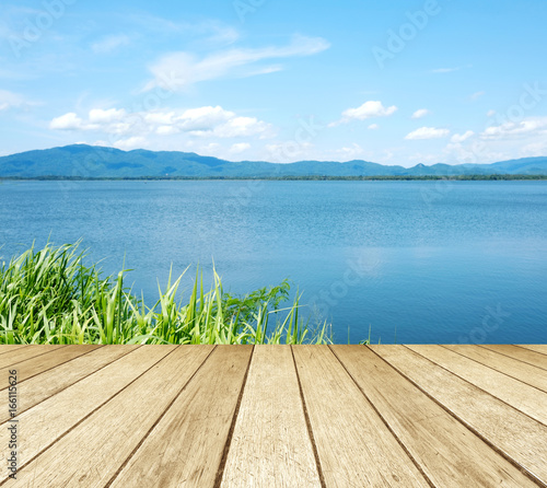 Empty perspective wood over lake and blue sky background, spring and summer season, nature background © mangpor2004