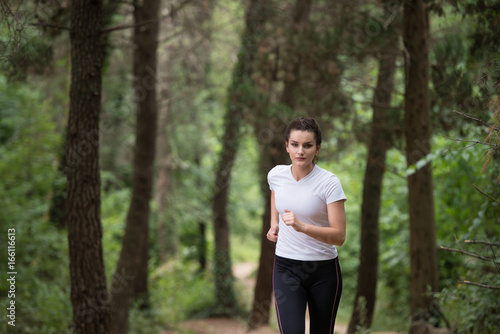 Woman Runner Running Through The Spring Park Road