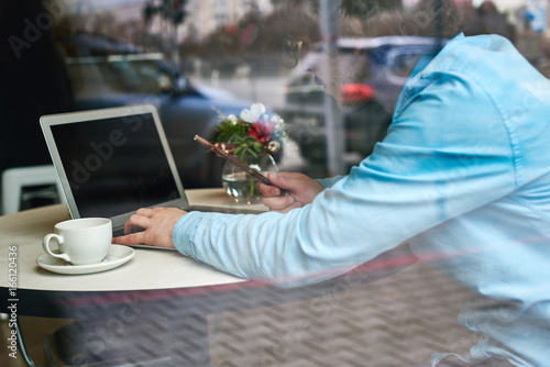 Look through the glass at a man working in a cafe