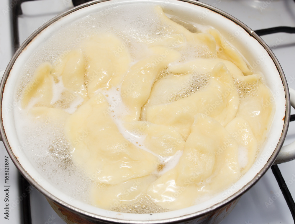 Vareniki with potatoes are cooked in a saucepan Vareniki with potatoes are cooked in a saucepan
