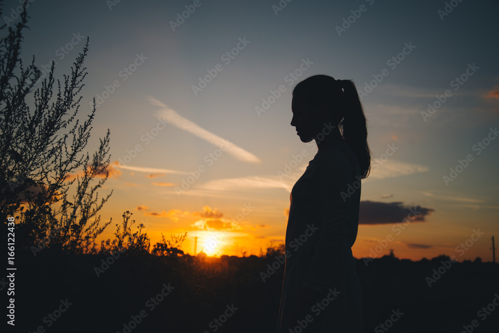 Silhouette of a woman with evening sky Silhouette of a woman with evening sky