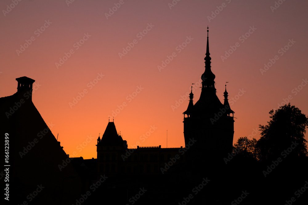 The medieval town of Sighisoara, Transylvania, Romania, silhouetted against sunset
