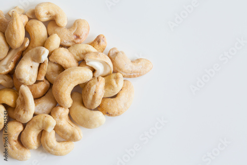 Heap of cashew nuts on white surface