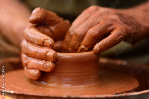 Potter making ceramic pot on the pottery wheel © byrdyak
