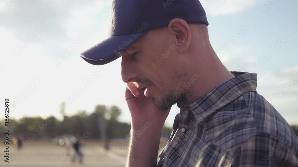 Young handsome man in a cap talking on the phone in the street. HD, 1920x1080. Slow motion Young handsome man in a cap talking on the phone in the street. HD, 1920x1080. Slow motion