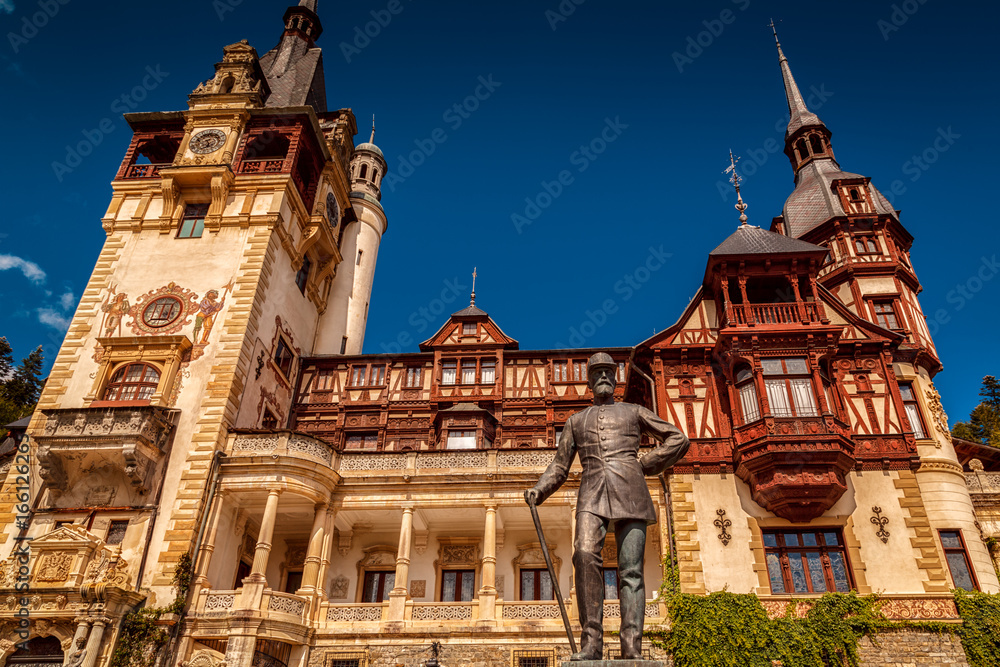 Wide angle shot of the statue of Charles I and the Peles Castle, Sinaia, Transylvania, Romania