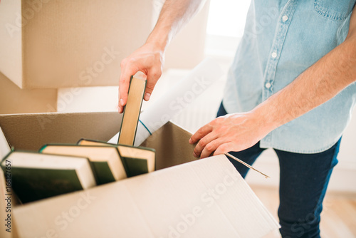 Young man unpacking cardboard boxes, housewarming © Nomad_Soul