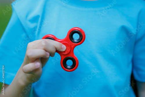 Little girl is playing spinner in hand photo