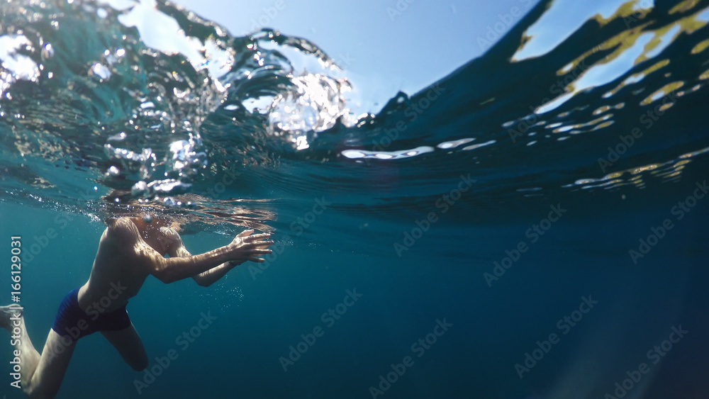 young man swims into the sea