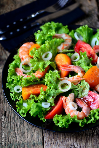 Healthy salad of red and yellow tomatoes, with shrimps, sweet onions, lettuce, balsamic vinegar and olive oil.