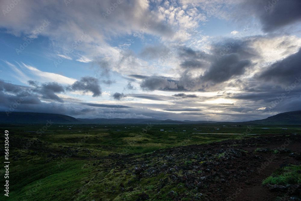 Iceland - Volcanic stones and green hills at dawn