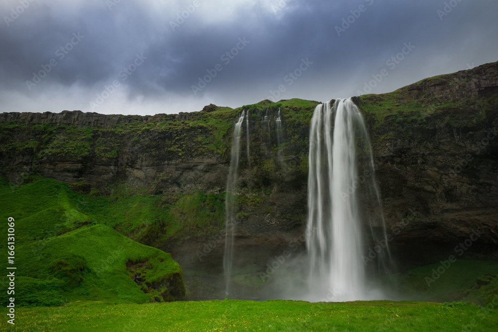 Iceland - Waterfall of Seljalandsfoss with green meadow Iceland - Waterfall of Seljalandsfoss with green meadow