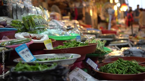 4K A traditional hawker selling green chilli peppers and other vegetables in korean street foods ingredients at Gukje International Market Busan. Korean vendors sell food in South Korea-Dan photo