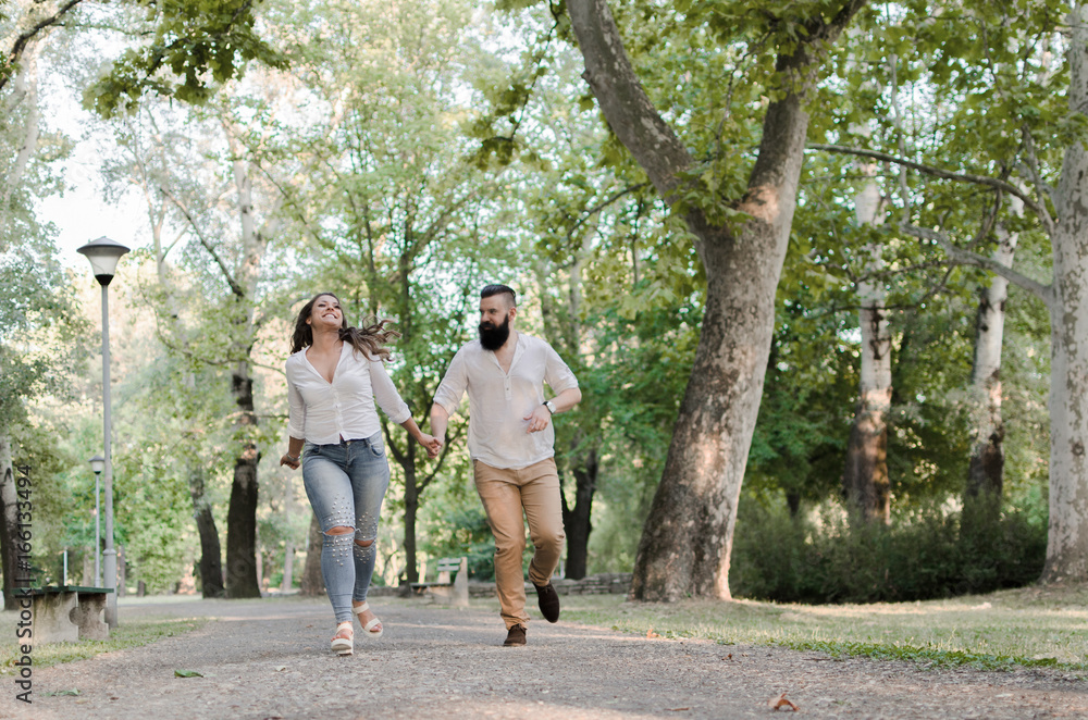 man and woman running in park and smiling