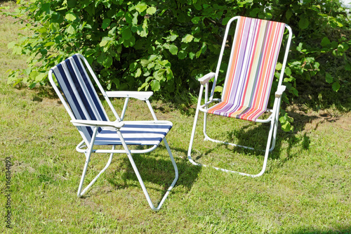 folding chairs on the lawn in the spring afternoon