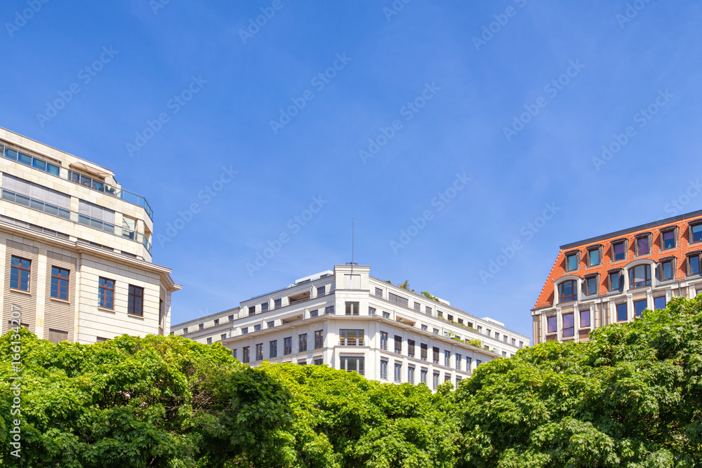 Beautiful building facades at Gendarmen Markt in Berlin beneath the blue sky.