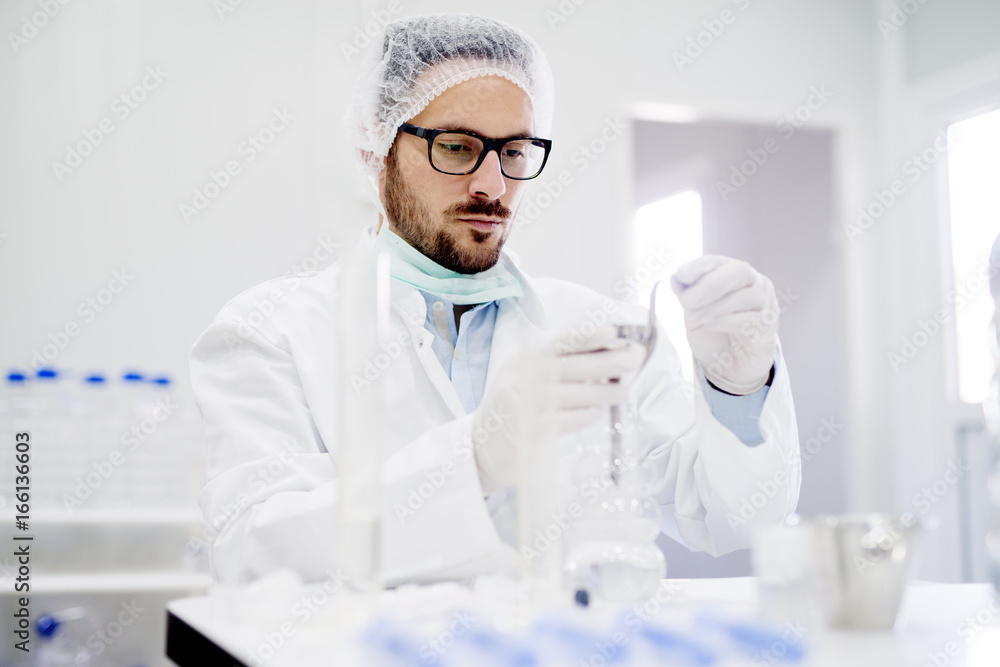 Close up of young biologist with gloves in laboratory.