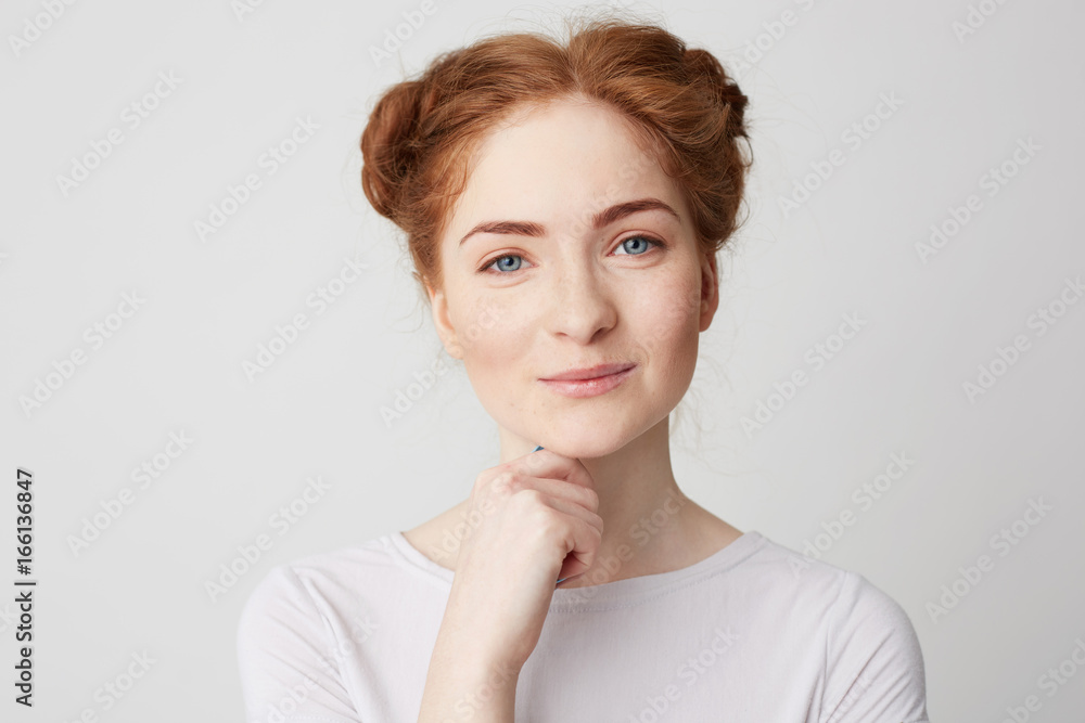 Portrait of young pretty girl with red hair smiling looking at camera touching chin over white background. Portrait of young pretty girl with red hair smiling looking at camera touching chin over white background.