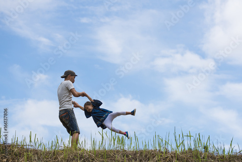 Father and daughter playing in the meadow