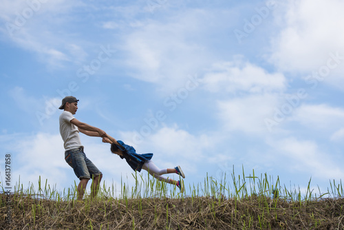 Father and daughter playing in the meadow