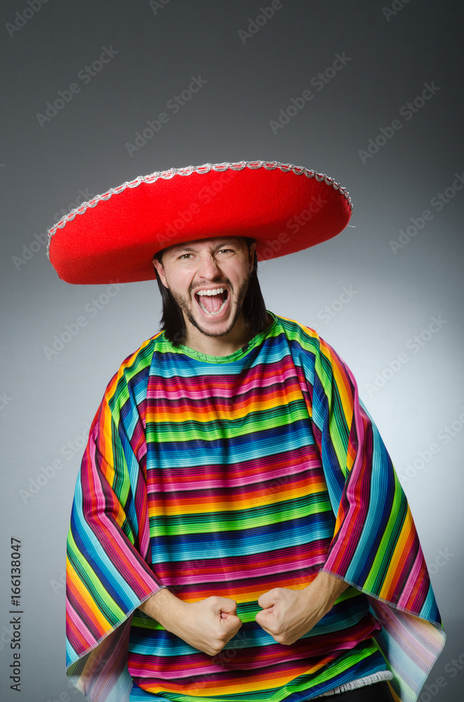Man in a vivid mexican poncho gray background isolated Man in a vivid mexican poncho gray background isolated