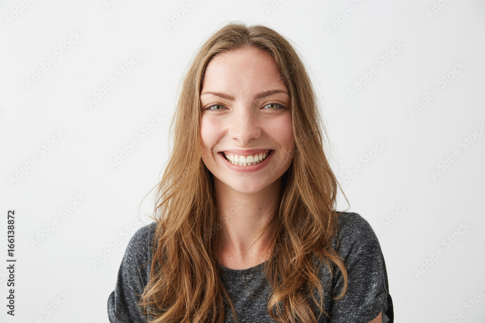 Naklejka premium Young cheerful happy girl smiling laughing looking at camera over white background.