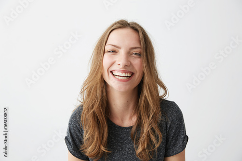 Young cheerful happy girl smiling laughing looking at camera over white background. photo