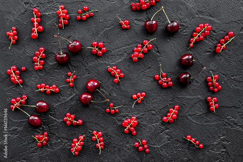 Berry pattern. Red currant, cherry on black table background top view