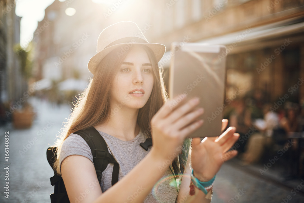 Female tourist using a tablet to search for interesting locations or find her way or just chatting with friends via video. Travel concept. Female tourist using a tablet to search for interesting locations or find her way or just chatting with friends via video. Travel concept.
