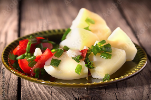 Boiled potato with tomatoes and green onions