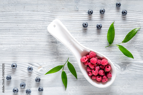 Paspberry and blueberry for preparing jam on grey wooden background top view copyspace photo