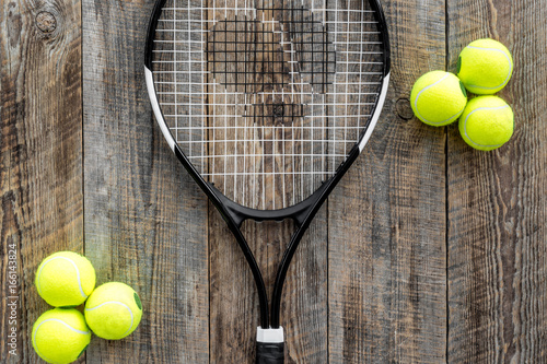 Sport background. Tennis balls and racket on wooden background top view copyspace © 9dreamstudio
