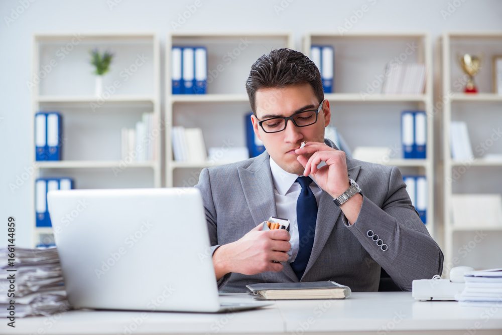 Businessman smoking in office at work