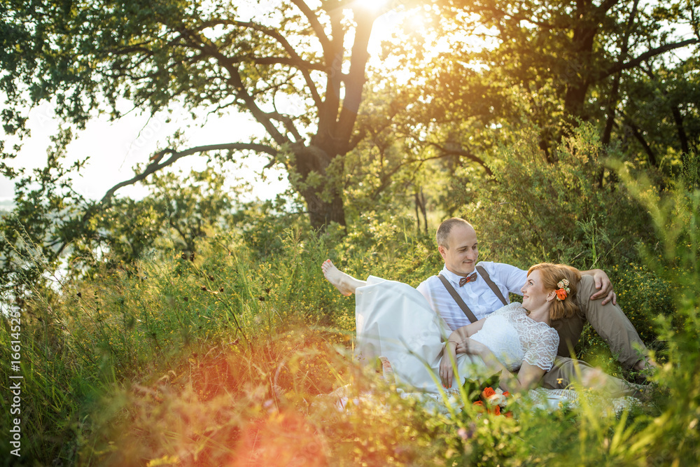 Attractive Couple Enjoying Romantic Sunset Picnic in the Countryside Attractive Couple Enjoying Romantic Sunset Picnic in the Countryside