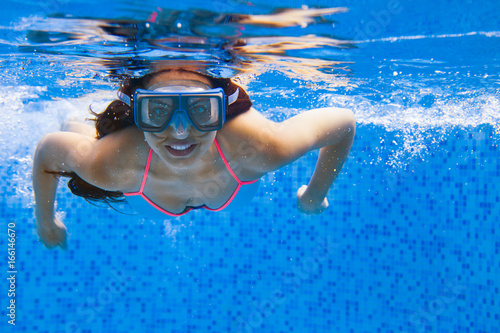 Portrait Young smiling woman swimming undewater in the swimming pool