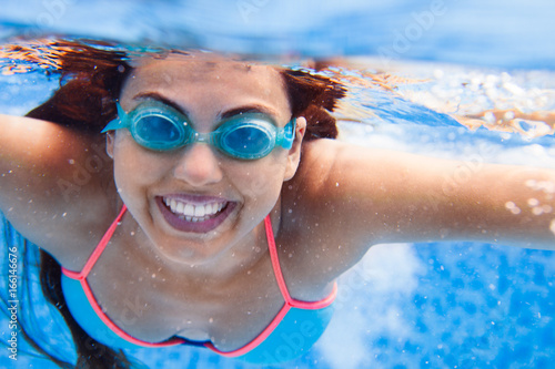 Portrait Young smiling woman swimming undewater in the swimming pool © yatcenko