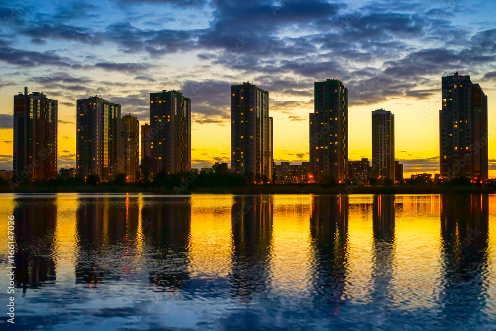 Buildings reflected in the water. Buildings at sunset.