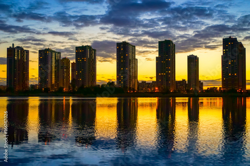 Buildings reflected in the water. Buildings at sunset. © Grispb